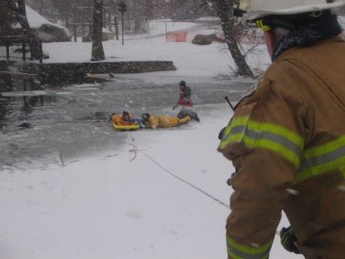 Firefighters remove a 'victim' from the water and prepare to pull them to shore
