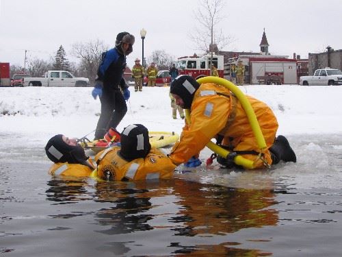 Firefighters prepare to remove a 'victim' from the icy water