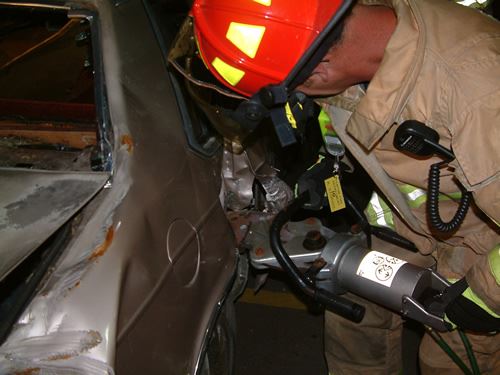 A firefighter working with a car